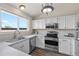 Bright kitchen features stainless steel appliances, white cabinets, and a large window above the sink at 3968 Ashcroft Ave, Castle Rock, CO 80104