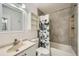 Bright bathroom featuring a shower-tub combo with gray tiling and a butterfly shower curtain at 10064 Owens St, Broomfield, CO 80021