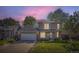 Attractive two-story home with a well-kept lawn and a spacious two-car garage under a pink hued sky at 10064 Owens St, Broomfield, CO 80021