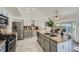 Bright open concept kitchen featuring an island with tile countertops and stainless steel appliances at 10064 Owens St, Broomfield, CO 80021