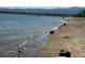 Scenic lakeside view featuring water, sand, and distant mountains on a sunny day at 10064 Owens St, Broomfield, CO 80021