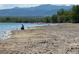 Lake shore with person fishing and the mountains in the distance at 10064 Owens St, Broomfield, CO 80021