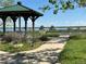 Picturesque view of the lake from a gazebo, with a paved walkway and ample green space at 10064 Owens St, Broomfield, CO 80021