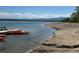 Scenic lake view with boats docked on a sandy shore and mountains visible in the distance at 10064 Owens St, Broomfield, CO 80021