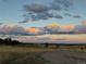 Expansive landscape featuring a dirt path leading to a distant horizon under a dramatic sunset sky at 10064 Owens St, Broomfield, CO 80021