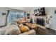 Bright living room with dark wood floors, brick fireplace, and sliding doors to the backyard at 10064 Owens St, Broomfield, CO 80021