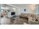 Bright living room with wood floors, a large sectional sofa, and modern staircase at 10064 Owens St, Broomfield, CO 80021