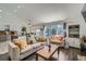 Open-concept living room featuring hardwood floors, vaulted ceilings, and sliding glass doors to the exterior at 10064 Owens St, Broomfield, CO 80021
