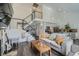Open-concept living room featuring hardwood floors, vaulted ceilings, and an open staircase to the second floor at 10064 Owens St, Broomfield, CO 80021