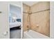 Cozy bathroom featuring a tiled shower-over-tub and a glimpse into the bedroom at 8757 E Dry Creek Rd # 1528, Englewood, CO 80112