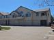 Charming condo complex featuring private garages and balconies under a clear blue sky at 8757 E Dry Creek Rd # 1528, Englewood, CO 80112