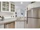 Functional kitchen layout with stainless steel dishwasher, refrigerator, and tile countertops at 8757 E Dry Creek Rd # 1528, Englewood, CO 80112