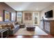 Comfortable living room with brown accent wall, gray couch, area rug, and media center at 10601 Montecito Dr, Lone Tree, CO 80124