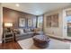 Living room with gray couch, decorative pillows, hardwood floors, area rug, and access to balcony at 10601 Montecito Dr, Lone Tree, CO 80124