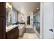 Well-lit main bathroom with tiled floors, soaking tub, separate vanities, and glass shower at 10601 Montecito Dr, Lone Tree, CO 80124