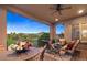 Covered porch with wicker seating, table, and views of green space beyond at 10601 Montecito Dr, Lone Tree, CO 80124
