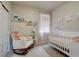 Cozy Bedroom with a rocking chair, soft pink accents, and a white crib, creating a soothing environment at 6612 N Ceylon St, Denver, CO 80249