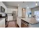 Modern kitchen featuring stainless steel appliances, granite countertops, an island with bar seating, and pendant lights at 6612 N Ceylon St, Denver, CO 80249