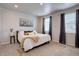 Serene bedroom with neutral tones, a large bed, soft lighting, and large windows with curtains at 6612 N Ceylon St, Denver, CO 80249