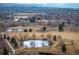 A scenic aerial view shows the property situated near a tranquil park with a pond and walking trails at 1492 S Dudley St, Lakewood, CO 80232