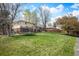 Lush backyard featuring a trampoline and mature trees, creating a perfect play area at 1492 S Dudley St, Lakewood, CO 80232