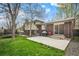 Spacious backyard features a concrete patio, lush lawn, and mature trees, creating an inviting outdoor space at 1492 S Dudley St, Lakewood, CO 80232