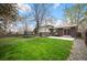 Spacious backyard featuring a well-maintained lawn, trampoline, and concrete patio perfect for outdoor entertaining at 1492 S Dudley St, Lakewood, CO 80232