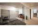 Finished basement with a large shelving unit, comfortable seating area, and carpeted flooring at 1492 S Dudley St, Lakewood, CO 80232