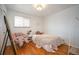 Bright bedroom with wood floors, large window, and a cute pink chair at 1492 S Dudley St, Lakewood, CO 80232