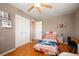 Bright bedroom with hardwood floors, a cozy bed with pink bedding, and closet with paneled doors at 1492 S Dudley St, Lakewood, CO 80232