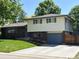 Charming two-story home with a brick facade, well-maintained lawn, and a blue garage door at 1492 S Dudley St, Lakewood, CO 80232