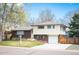Charming home featuring a well-maintained lawn, brick accents, and a two-car garage at 1492 S Dudley St, Lakewood, CO 80232