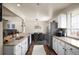 Open kitchen has stainless appliances, granite countertops, and tile flooring at 1492 S Dudley St, Lakewood, CO 80232