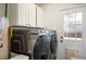 Convenient laundry room with modern washer and dryer units and overhead cabinets at 1492 S Dudley St, Lakewood, CO 80232