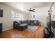 Spacious living room with hardwood floors, a large sectional sofa, and a ceiling fan for added comfort at 1492 S Dudley St, Lakewood, CO 80232