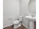Modern bathroom with a pedestal sink, round mirror and fixtures at 2145 Flower Blossom Ave, Brighton, CO 80601