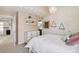 Light and airy bedroom with neutral tones, vaulted ceiling, decorative chandelier, and open doorway to a bathroom at 11302 E Ida Ct, Englewood, CO 80111
