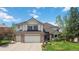 Charming two-story home featuring a well-manicured lawn, a three-car garage, and a beautiful brick and siding facade at 11302 E Ida Ct, Englewood, CO 80111