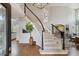 Elegant foyer showcasing a curved staircase with wrought iron railings, hardwood floors, and a soaring ceiling at 11302 E Ida Ct, Englewood, CO 80111