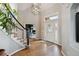 Bright foyer features hardwood floors, a staircase with black accents, and a view into a well-lit office space at 11302 E Ida Ct, Englewood, CO 80111