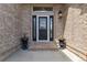 Inviting front entrance with a decorative glass door, brick accents, and charming planters creating a warm welcome at 11302 E Ida Ct, Englewood, CO 80111