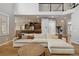 Open-concept living room showcasing a large sectional sofa, hardwood floors, and seamless flow into the kitchen at 11302 E Ida Ct, Englewood, CO 80111
