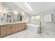 Bathroom featuring double vanity, soaking tub and skylight for natural light at 8188 S Yukon St, Littleton, CO 80128