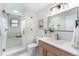 Stylish bathroom with a glass shower, modern vanity, updated fixtures, and a decorative mirror at 8188 S Yukon St, Littleton, CO 80128