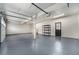 Spacious garage with painted floor, shelving, and access door at 8188 S Yukon St, Littleton, CO 80128