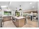 Open kitchen with stainless steel appliances, an island with seating, and views into the living area at 8188 S Yukon St, Littleton, CO 80128
