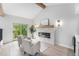 Bright living room with wood floors, stone fireplace, vaulted ceilings, and doors to the balcony at 8188 S Yukon St, Littleton, CO 80128