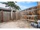 Enclosed backyard area featuring a privacy fence, trees, yard waste container, and a concrete patio at 12662 W Virginia Ave, Lakewood, CO 80228
