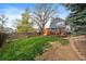 Backyard featuring a deck, sauna, green grass, privacy fence, and a two-story blue house at 8508 Vivian Ct, Arvada, CO 80005