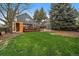 Spacious backyard featuring a lush lawn, wooden deck, shed, and sauna, perfect for outdoor enjoyment and relaxation at 8508 Vivian Ct, Arvada, CO 80005